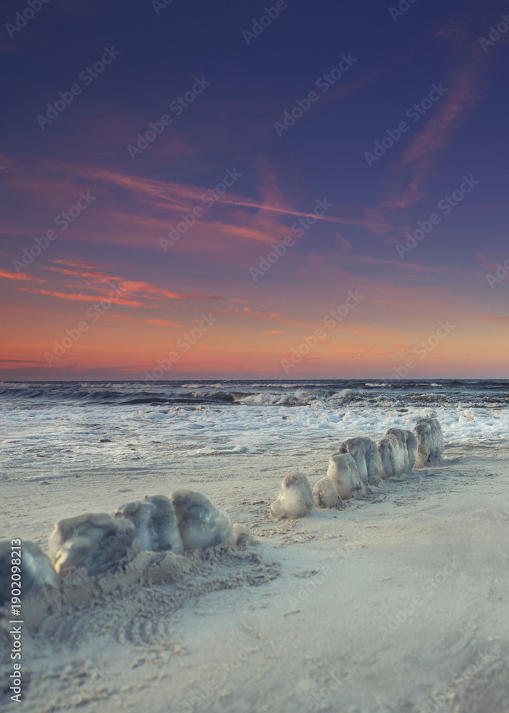 Fototapeta premium snow and ice on the beach with cold winter sunrise 