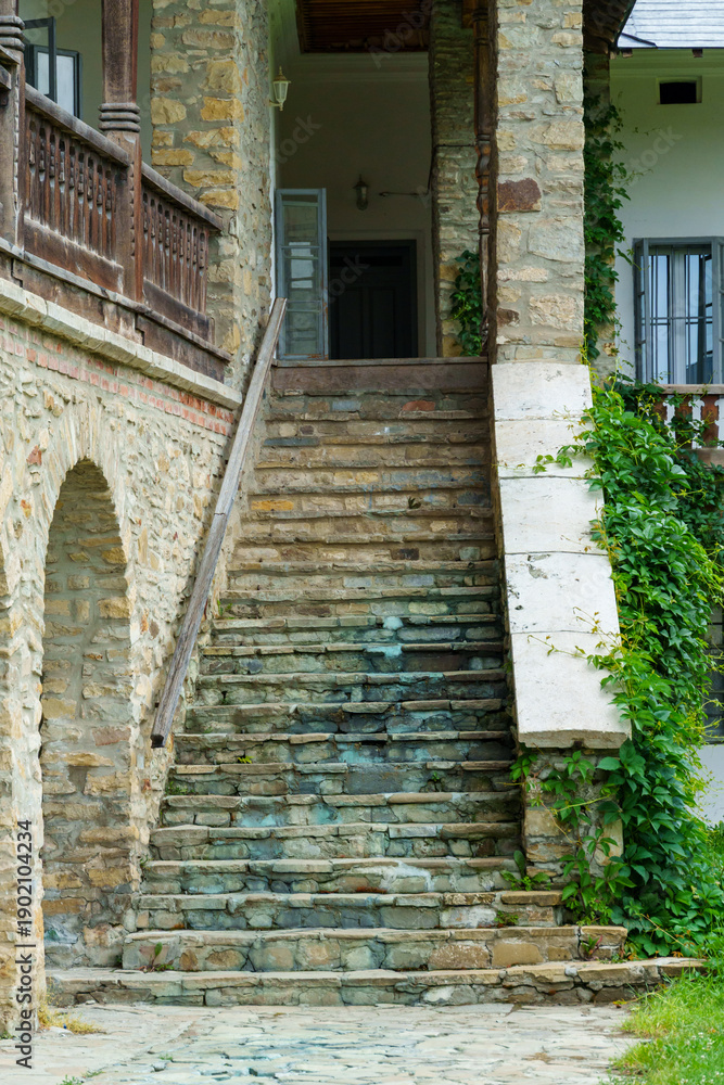Naklejka premium view of the facade of an old house with a stone steps and porch and arches