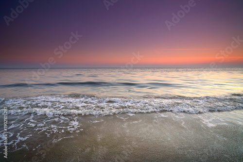 Slowly rushing waves on the beach of the Baltic Sea while sunset