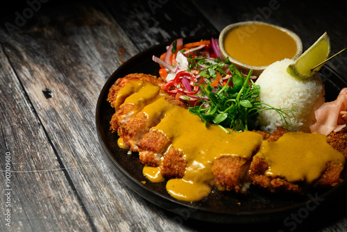 Chicken katsu curry with rice on rustic table