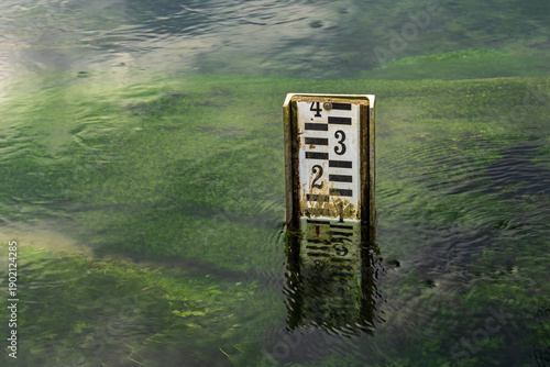 Foto water level gauge partially submerged in clear river