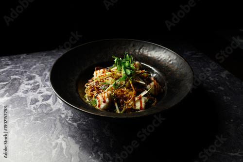 A bowl of food with a green garnish on top
