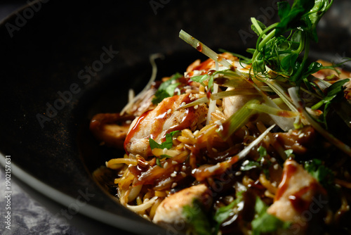 A bowl of Asian food with chicken and vegetables
