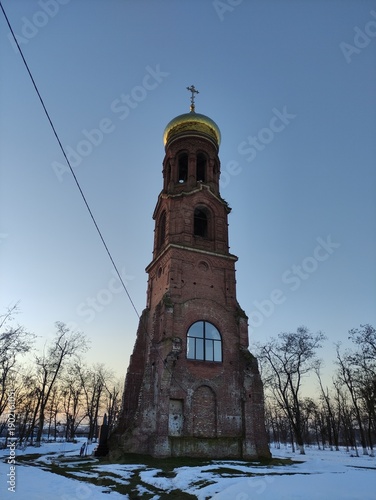 Old pre-revolution Orthodox chapel with golden dome and cross in winter, vertical photo