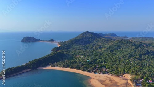 Aerial view of tropical coastline with lush jungle hills, sandy beaches, and clear blue sea surrounding peaceful Koh Phayam island.