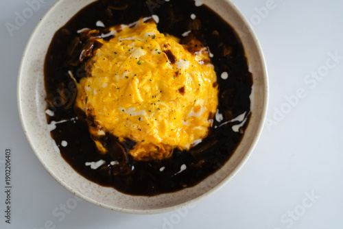 Top view Japanese omurice with creamy scrambled egg on rice served with rich demi glace sauce, gourmet comfort food presentation.