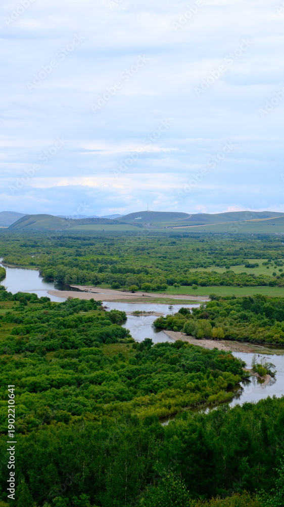 Obraz premium A sweeping panoramic view of Erguna Wetland in Hulunbuir, Inner Mongolia, showcasing vast rivers, forests, marshes, and seasonal color.