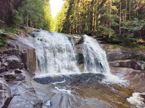 Fotografie vigorous waterfalls cascade onto rugged stones, dynamic river descent over grani