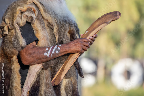 Human hand holds ritual clapsticks for the welcome ritual rite at an indigenous community event in Australia