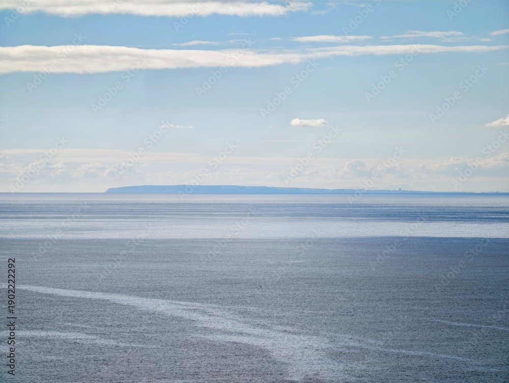 Αυτοκόλλητο Serene scene depicting layered cloud formations over placid sea with subtle past