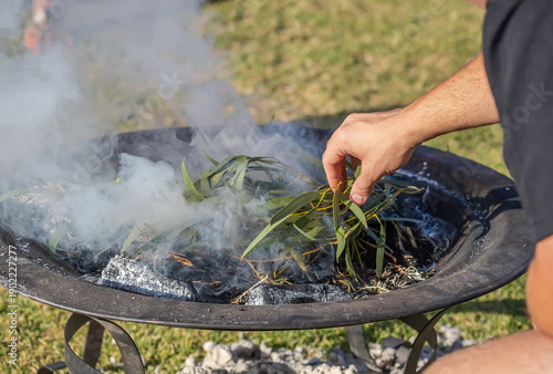 Foto Human hands with green branches, smoking ritual dish, Australian aboriginal smok