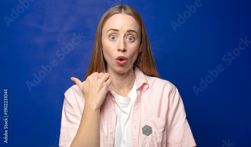 Foto looking astonished in disbelief, pointing at object on the side and saying wow,