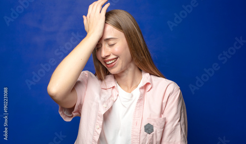 Foto laughing and slapping forehead like saying d’oh! I forgot or that was a stupid m