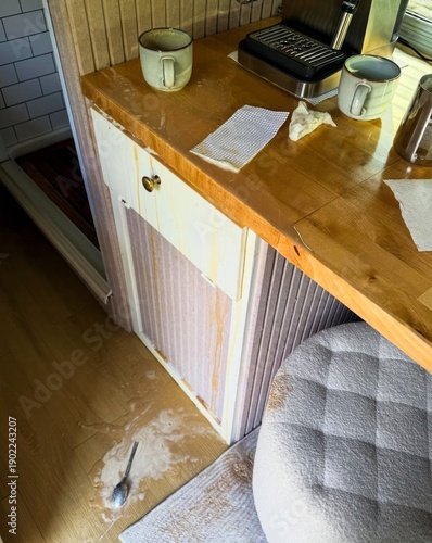 Fotografie A rogue teaspoon lies abandoned on a rustic kitchen floor, echoing quiet morning