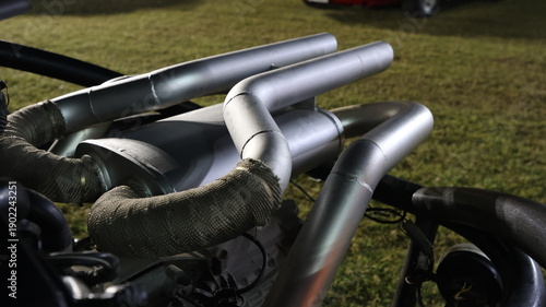 Fotografie Close up of custom silver car exhaust system with fiberglass heat wrap tape