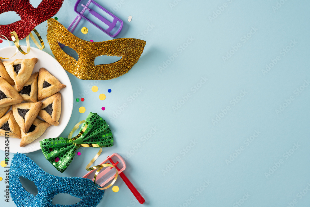 Fototapeta premium Vibrant Purim scene featuring glittery masks, hamantaschen cookies, party noisemakers, and colorful confetti. A playful, celebratory mood perfect for holiday greetings and seasonal stock content