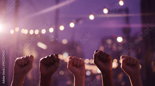 Five diverse female hands raised in clenched fists against a soft sunset bokeh background. A powerful symbol of women's rights, solidarity, and the fight for equality.