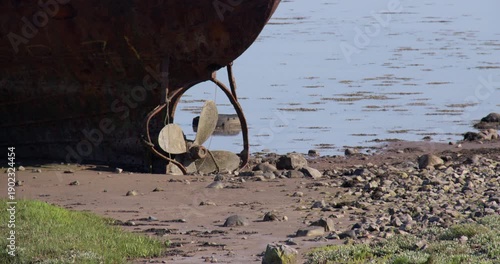 mid shot of a Abandoned dialect wreck fishing boat showing the propellers at Roa Island, barrow in furness,