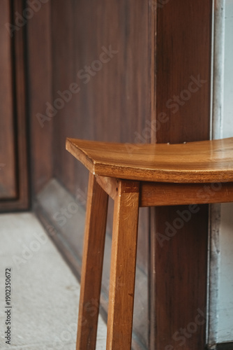 A scratched wooden chair outside of a store