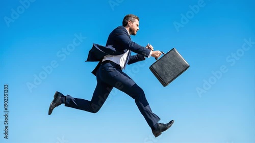 A businessman running and jumping against a clear blue sky, symbolizing career advancement and freedom