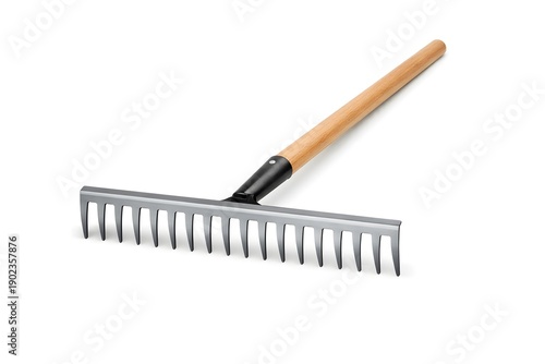 A raking tool with a long wooden handle and metal tines is placed flat. It is used for gathering leaves, soil, or debris in an outdoor setting during springtime