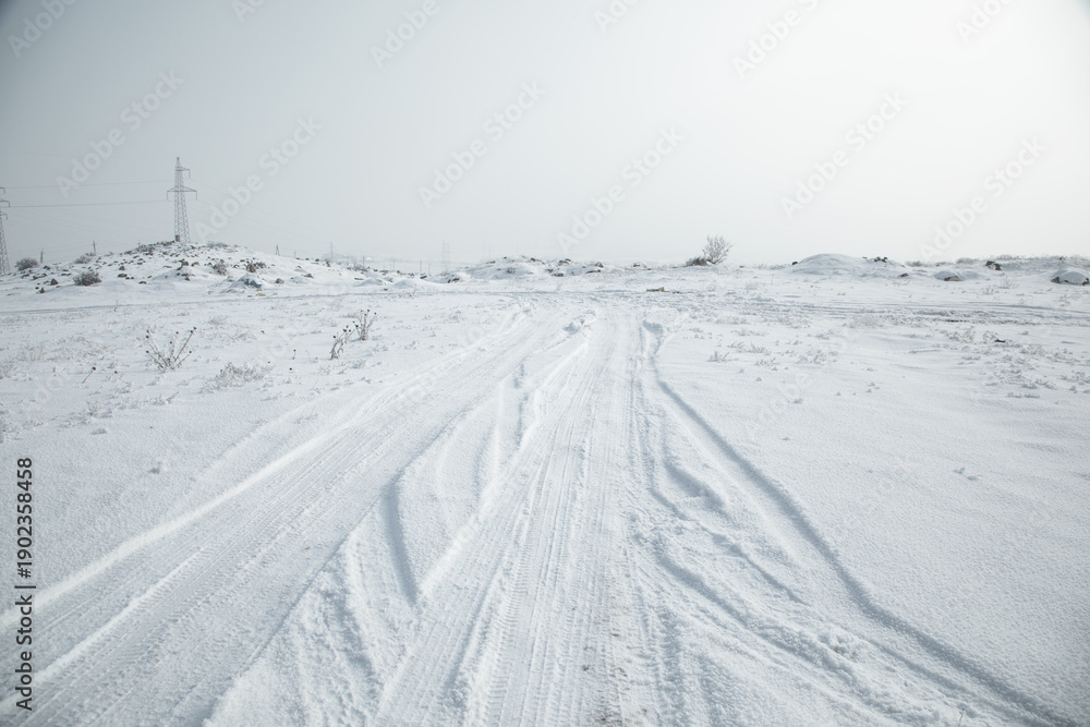 Fototapeta premium Car tire tracks in snow at winter.