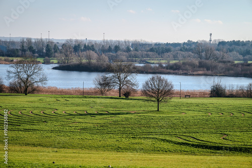 Turf maze labyrinth and a part of North Willen Lake seen from a distance on a winter day, Milton Keynes, UK