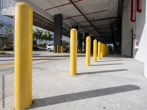 Bild auf Leinwand Yellow parking bollards in a car parking garage