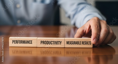 Manager placing wooden blocks labeled performance productivity and measurable results signifying business strategy implementation
