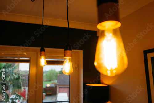 Fotografie The room is lit by three light bulbs, two of which are yellow and one is white