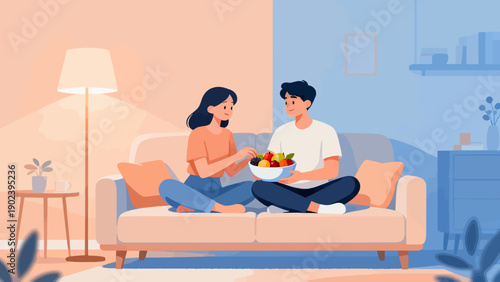 A man and woman are sitting on a couch, eating fruit. Scene is relaxed and comfortable