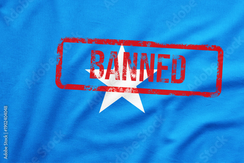 Blue Somalian national flag with red stamp BANNED on it. Fraud Awareness and Scam Prevention Concept.