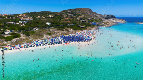 Aerial view of the crowded paradise beach La Pelosa in Stintino, Sardinia, Italy