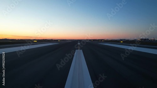 Airport runway at sunrise. Airplane taxiing on empty airfield with markings for travel and transportation concept