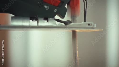 A high-speed electric jigsaw saw blade rapidly rotates, enabling precise cutting through various wooden materials and boards, streamlining the material processing operation electronically