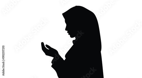 A woman in traditional hijab praying a striking black silhouette