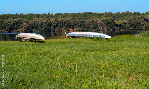 Bilde på lerret two long canoes lie upside down on the grass with their hulls facing upwards on