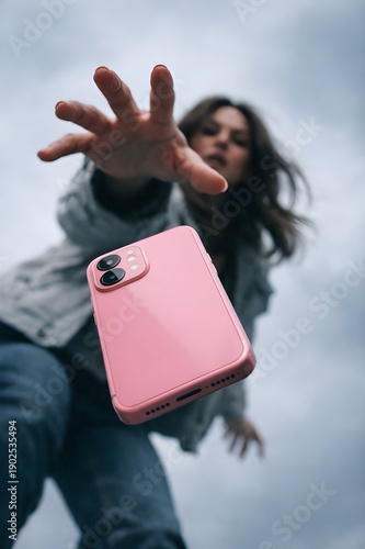 woman hand falling pink color smart phone closeup looking photography