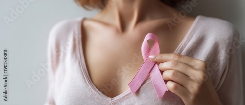 The Pink Ribbon Held Over a Woman's Chest Symbolizing Breast Cancer Awareness
