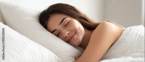 The woman sleeping peacefully on white bedding in a bright cozy bedroom