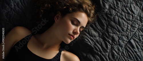 The Sleeping Woman in Soft Natural Light on Dark Quilted Bedding