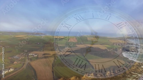 Camera starting forward gliding over coastal fields, dim clock shifting moon drifting, showing time