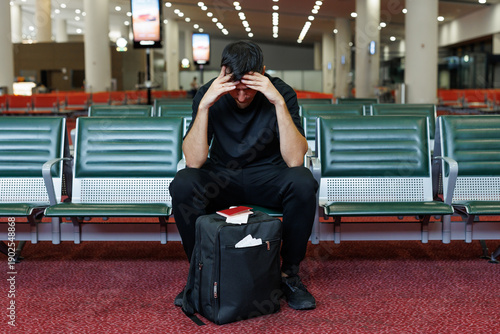Traveler experiencing stress and frustration from flight delay or cancellation.