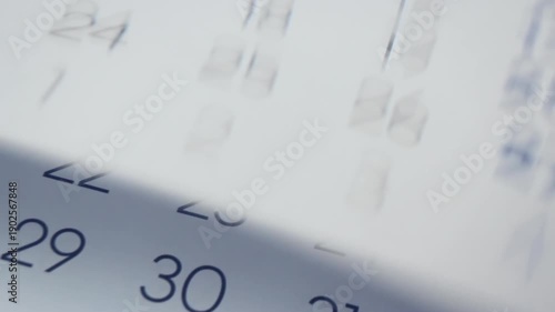 Time passing and inevitable changings concept. Close Up of paper calendar with pages turning quick