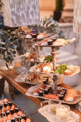 Trays of sushi in differents levels and sorts. The decoration is classic with stone and wood.