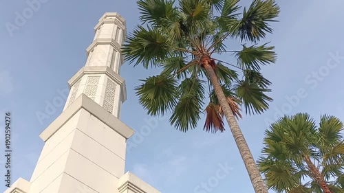 The modern architectural footage of mosque minarets and lush palm trees captures the blend of religious tradition and tropical scenery.