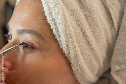 Woman blending eyeshadow with a makeup brush on her face.
Beauty and skincare routine concept. Professional makeup application, cosmetics, self-care, and personal grooming. Close-up portrait.