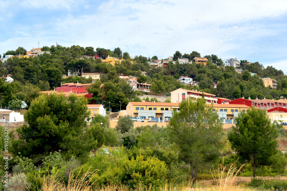 Obraz premium Colourful Houses on mountainside on Sunset. Residential buildings in town at Valencia mountains. Panoramic of Gilet, Spain city. Home on mountain. Village with colourful house in rural. Hoses in Town