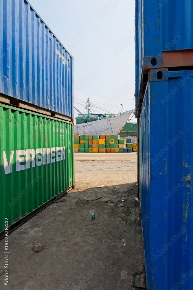 Fototapeta premium Jakarta Indonesia - 20 July 2025 - Stacked sea containers in the old harbor Sunda Kelapa with wooden cargo ships in Jakarta Indonesia