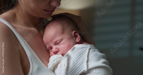Gentle mother cradles her peaceful newborn baby, fostering a sense of warmth and security in a tender moment. Mother Holding Sleeping Newborn Baby